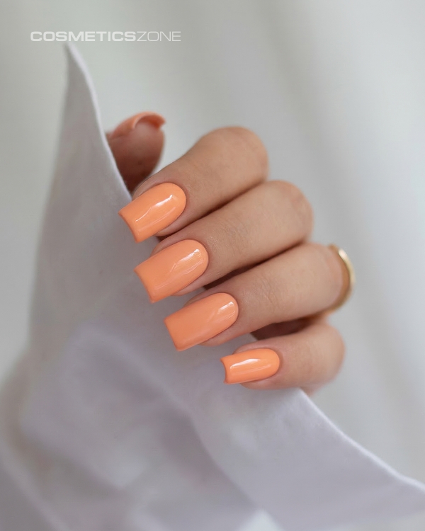 Dlonie-z-manicure-hybrydowym-w-kolorze-A020--soczysty,-brzoskwiniowy-odcien-na-paznokciach-o-kwadratowym-ksztalcie.webp